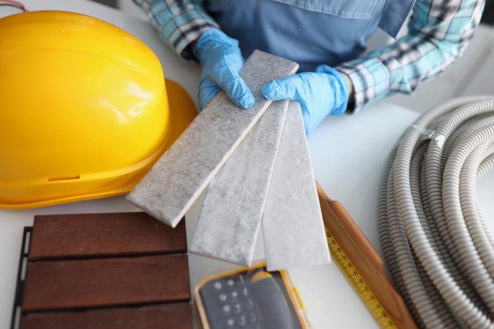 Builder hold grey tiles samples for bathroom in workshop, foreman choose perfect shade